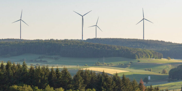 Wind turbines at the horizon in green rural landscape in Werbach